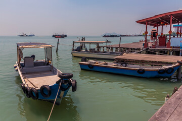 Fototapeta na wymiar Fishing boats moored at the clan jetties with the Penang bridge in the distance in George Town, Penang Island, Malaysia, Asia