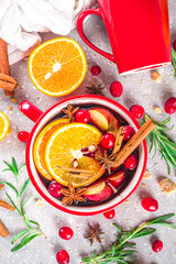 Mulled Wine Hot Drink with Citrus and Spices, Traditional Autumn Winter Warm Alcohol Beverage, in small portioned red stewpan or mug  with Mulled Wine Ingredients - fruit and spices, copy space