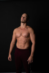 A sports guy of beautiful strength builds muscles in training. Strong bodybuilder with perfect abs, shoulders, biceps, deltoid and radial wrist flexor.