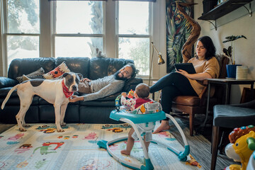 family with baby and dog hanging out together in living room of home