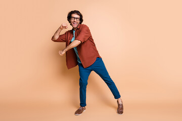 Full length photo of guy dance open mouth look camera wear eyewear brown t-shirt pants shoes isolated beige color background