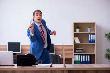 Young male employee playing darts in the office