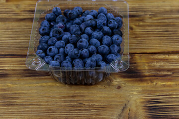 Fresh blueberry in plastic box on a wooden table