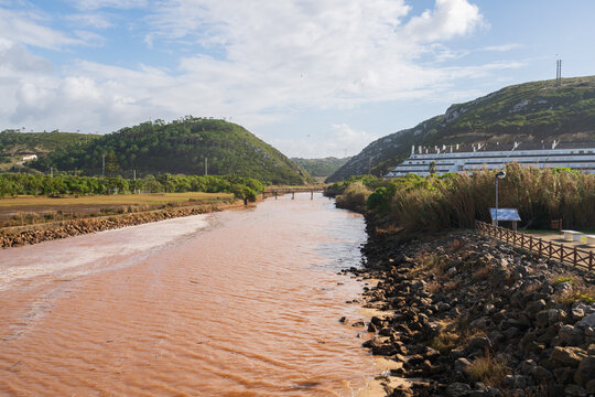 Maceira landscape with brown alcabrichel river and nature landscape hills on the background