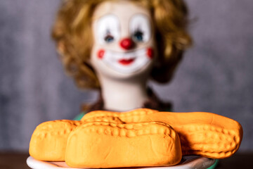 closeup of orange marshmallow circus peanuts with clown doll in background