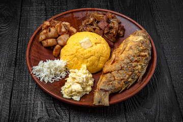 Fried crucian carp, mamalyga (polenta) stew, homemade feta cheese. Moldavian, Romanian traditional food. Festive table with delicious food.
