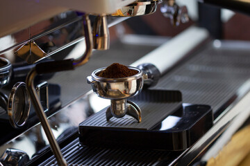 Fototapeta na wymiar Portafilter with freshly ground morning coffee on the scales