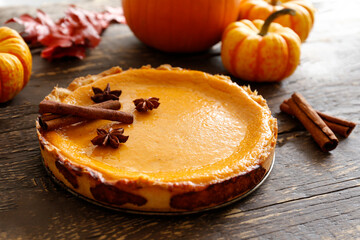 Traditional thanksgiving food on wooden table. Orange delicious homemade pumpkin pie with crust and...