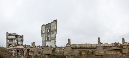 Panorama. The remains of a large destroyed building with piles of construction debris.