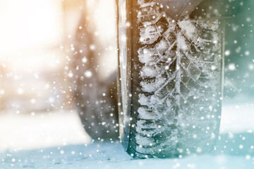 Close-up of car wheels rubber tires in deep winter snow. Transportation and safety concept.