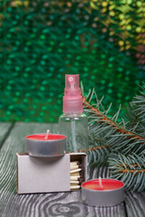 Branches of blue spruce on pine boards. Nearby are red candles, a box of matches and an antiseptic. Close-up shot.