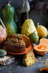 Homemade Pumpkin Bread. Yeast-free baking. Bread among many different pumpkins. Autumn pastries.