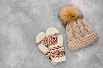 winter clothes mittens and knitted haton a Gray stone background