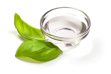 White Vinegar in a glass bowl with basil leaves, isolated on white background