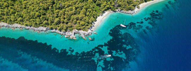 Aerial ultra wide panoramic view of tropical paradise rocky bay visited by sailboats and yachts in Caribbean exotic destination island