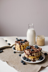 Delicious pancakes with blueberries, chocolate and a bottle of milk. Healthy eating. Morning tasty homemade breakfast, stack of fluffy and delicious sugar free pancakes. White background.