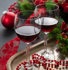 Christmas red wine glasses and xmas decoration on the table, closeup view