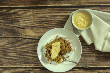 Piece of Apple and blueberry crumble with English cream