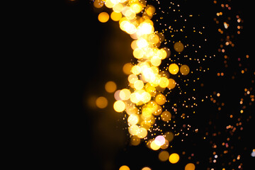 Weihnachtlich Goldenes Bokeh auf einem schwarzem Hintergrund mit einem Licht Schimmer.
