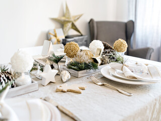 Festive living room decorated for Christmas and New Year with stylish table set and vintage Christmas decoration. Simple living, hygge concept.