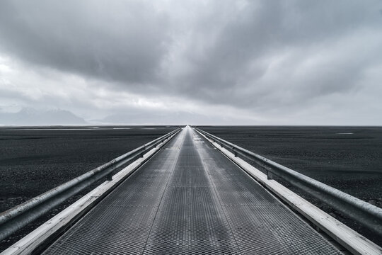 Skei&eth;ar&aacute;rsandur bridge leading over sandur towards Skaftafell and Vatnaj&ouml;kull glacier on  a stormy day