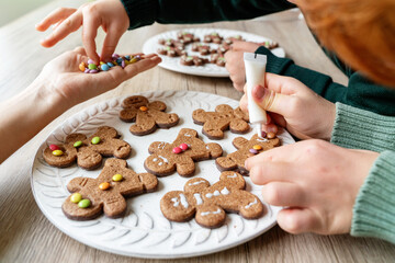 Horizontal view of home made ginger cookies on a plate in the kitchen. Christmas recipe of traditional sweet chocolate desserts for the festivities. Lifestyle with kids at home.