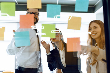 Business colleagues brainstorm with sticky notes at work in office