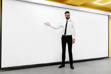 Fototapeta premium Young business man showing diagram on flyboard to creative team in office in conference room. business, startup, presentation, strategy