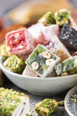 Baklava, halva, rahat lokum, sherbet, nuts, pistachios, in bowl on grey background. Assorted traditional eastern desserts, arabian sweets, turkish delight.