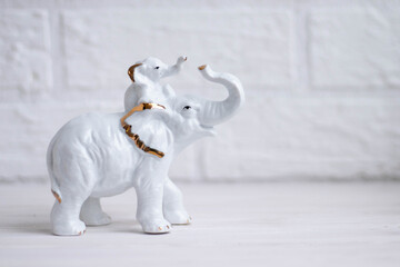 white elephant with a small elephant on its back porcelain figurine on a white background with...