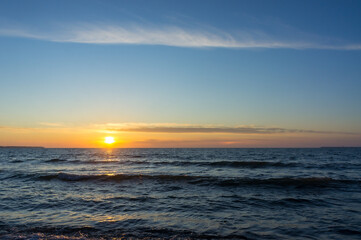 Sunset over the sea. Reflection of sunlight in the sea waves. The sky in the sunset. Baltic sea.