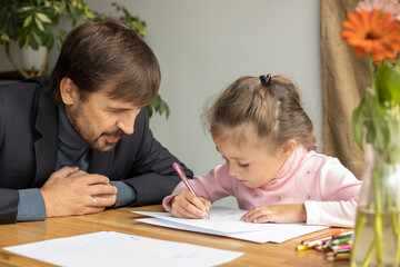 Young girl doing homework during extra-curricular classes with a tutor