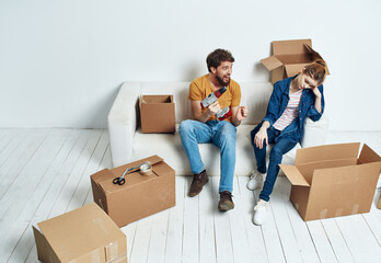 Fototapeta na wymiar Married couple in new apartment moving boxes with joy things
