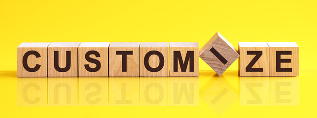 customize word is made of wooden building blocks lying on the yellow table, concept