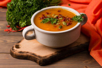 Pumpkin soup with herbs and spices, in a white plate. View from above