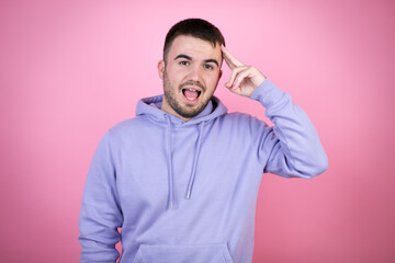 Young handsome man wearing casual sweatshirt over isolated pink background smiling and thinking with her fingers on her head that she has an idea.
