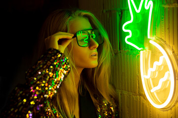 Neon Portrait. Retro wave. Blonde girl with glasses looking to light. Neon yellow and green  colors.