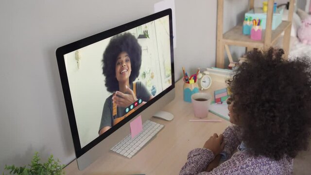 African American Kid Girl Talking To Friend, Sister Or Distance Teacher During Online Virtual Family Chat Videocall Meeting On Holiday By Video Conference Call Using Computer Sitting At Home.