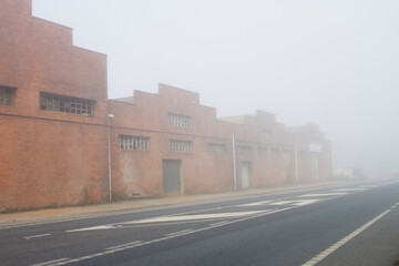 A factory on the road covered in fog
