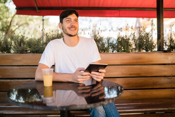 Young man using a digital tablet at coffee shop.