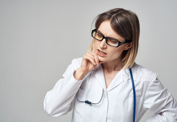 doctor in a medical gown with a stethoscope around his neck puzzled look gray background
