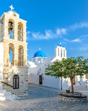 Traditional Cycladitic alley with a narrow street, whitewashed houses and a church in kostos  Paros island, Greece