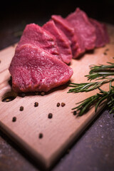 Beef on a cutting board with spices and rosemary