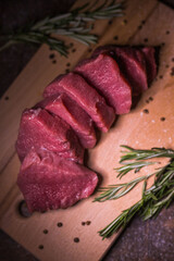 Beef on a cutting board with spices and rosemary