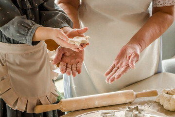 grandma teaches her granddaughter to cook ginger cookies