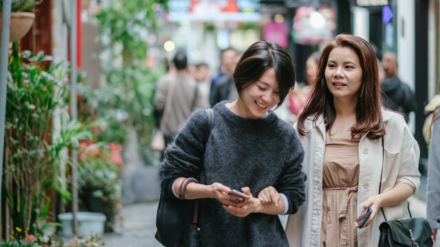 Two Young Women Shopping On Street