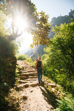 Outdoor portrait of a Young woman on a trek in the mountains - fully equipped with a backpack.