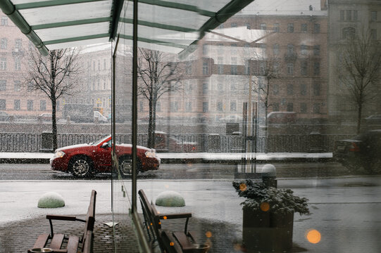 Car on a snowy dday in Saint Petersburg, Russia. Reflection seen in a glass bus stop.