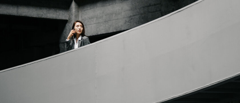 Businesswoman Using Cell Phone In Office Buildings