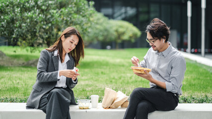 Businessman And Businesswoman Eating Lunch Together